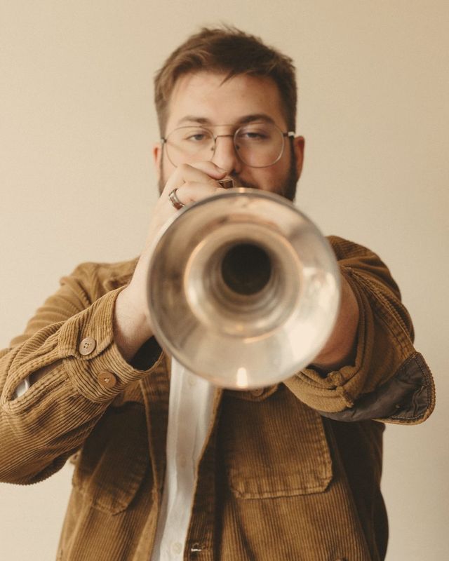 Christian Dyble playing trumpet with the bell pointed toward the camera
