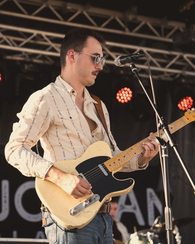 Tyler Furrer playing a butterscotch Telecaster on an outdoor festival stage